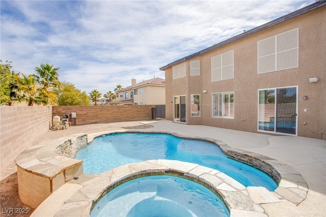 view of pool featuring a patio, a fenced backyard, and a pool with connected hot tub