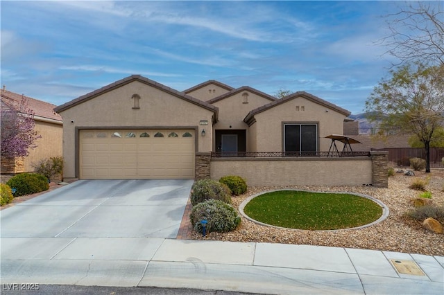 mediterranean / spanish-style house with a fenced front yard, a garage, concrete driveway, a tiled roof, and stucco siding