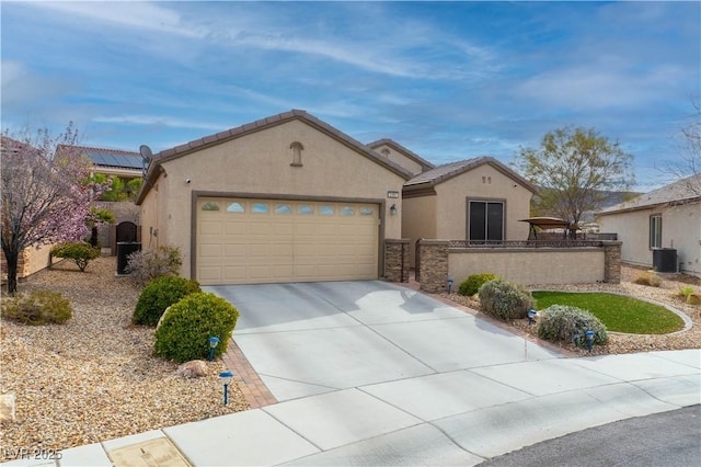 view of front facade featuring a garage, driveway, fence, and stucco siding