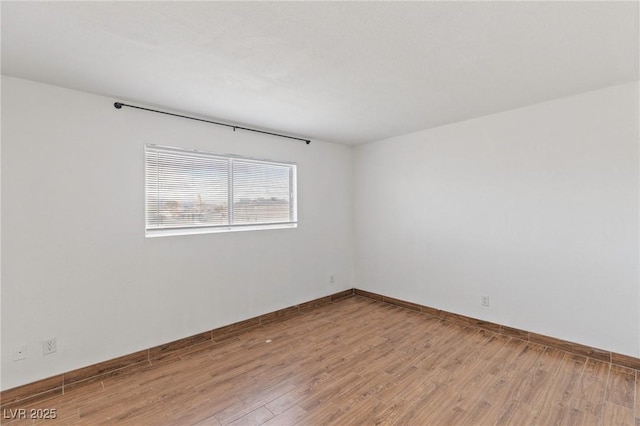 empty room with light wood-style flooring and baseboards