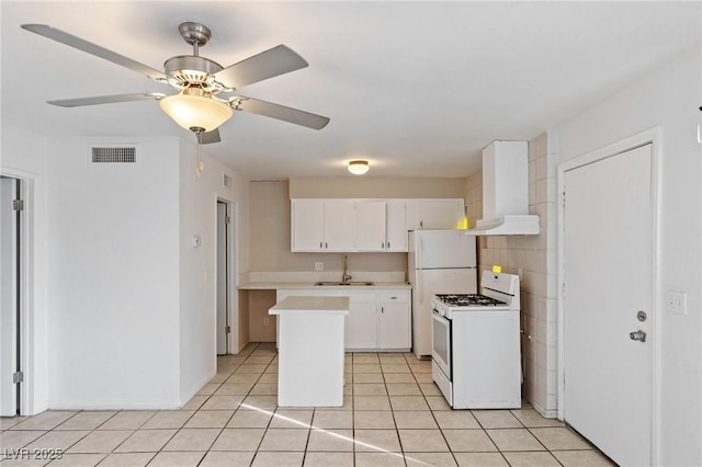 kitchen featuring white appliances, visible vents, white cabinets, light countertops, and a sink