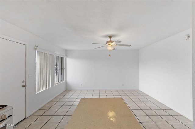 empty room featuring light tile patterned flooring and ceiling fan