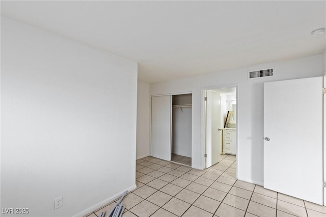 unfurnished bedroom with a closet, visible vents, baseboards, and light tile patterned floors