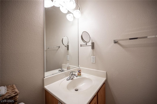 bathroom featuring a textured wall and vanity