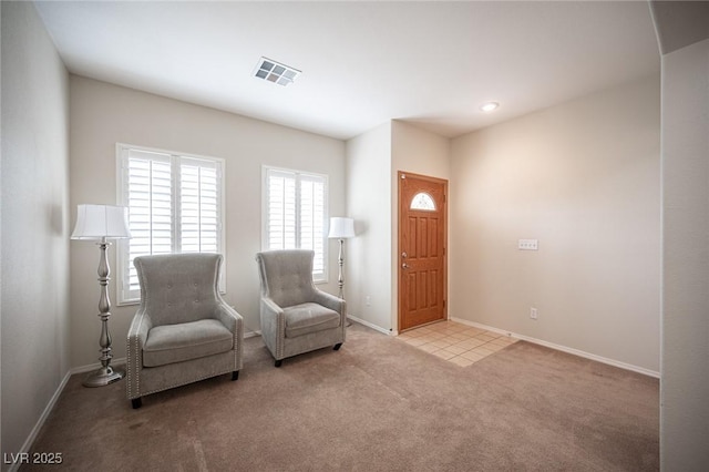 sitting room with baseboards, visible vents, and carpet flooring