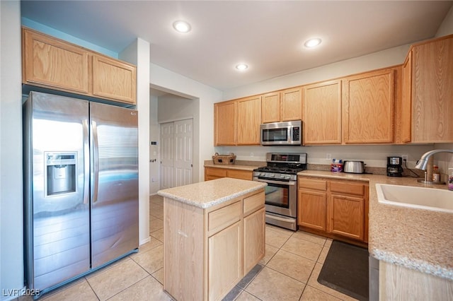 kitchen with appliances with stainless steel finishes, light brown cabinets, a sink, and light tile patterned floors