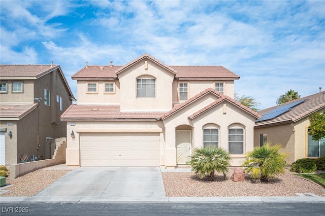 mediterranean / spanish-style house with driveway, stucco siding, a garage, and a tiled roof