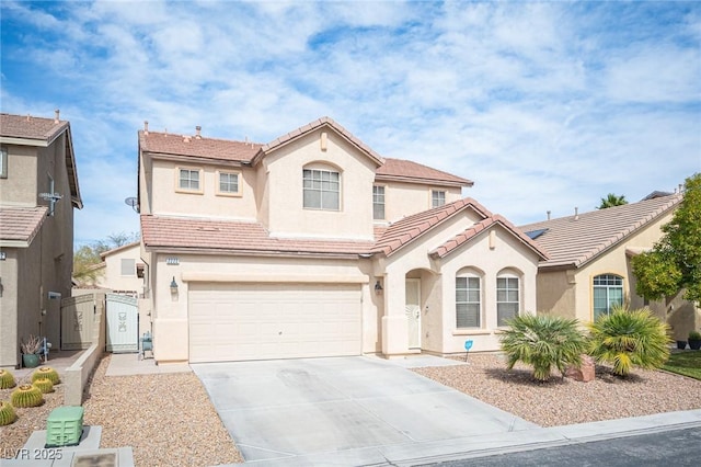 mediterranean / spanish home with driveway, a tile roof, a gate, and stucco siding