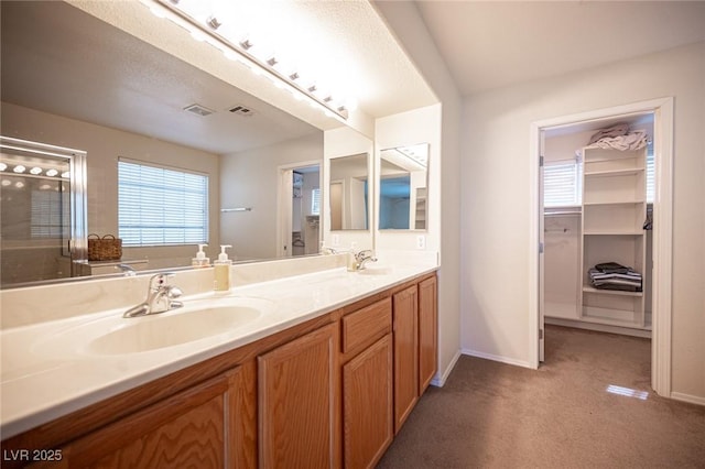 bathroom with a sink, baseboards, and double vanity