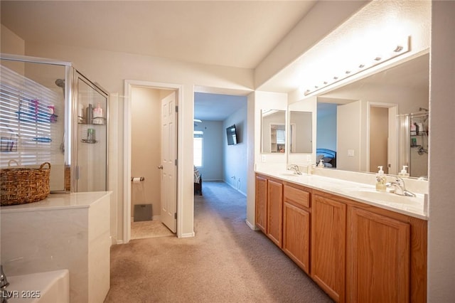 bathroom featuring connected bathroom, a stall shower, a sink, and double vanity