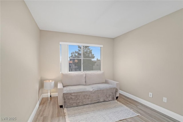 living area featuring light wood-type flooring and baseboards