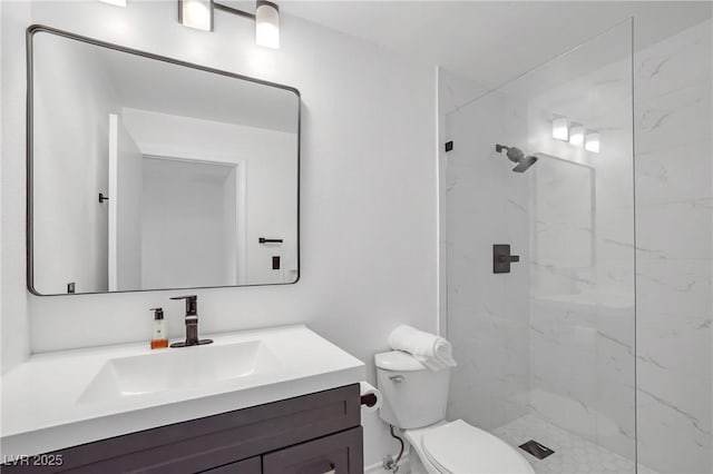 full bath with a marble finish shower, vanity, and toilet