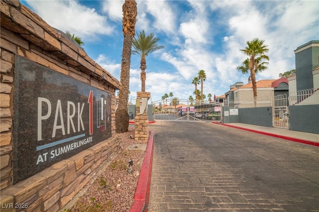 view of street featuring curbs, a gated entry, and a gate