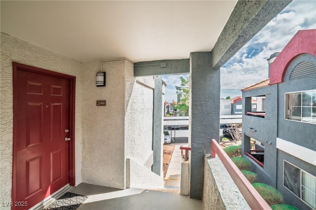 entrance to property featuring a balcony and stucco siding