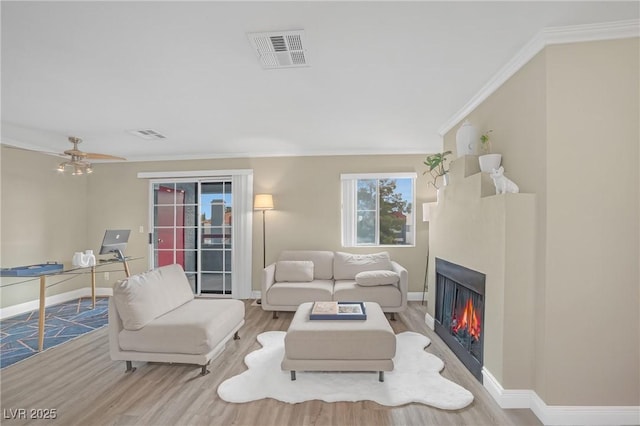 living room featuring baseboards, visible vents, and wood finished floors