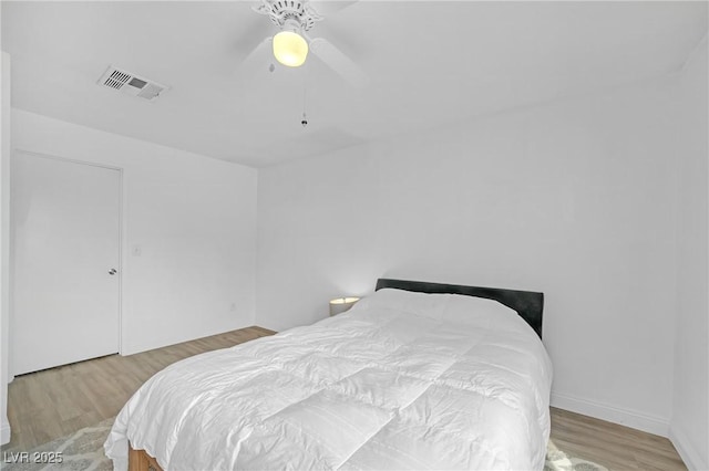 bedroom featuring ceiling fan, visible vents, and wood finished floors