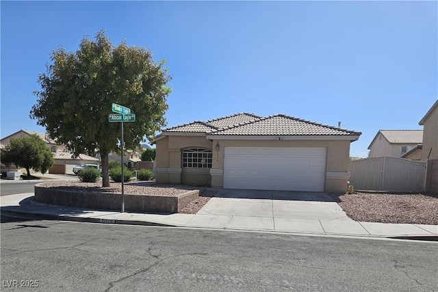 view of front of property with driveway, a tile roof, a garage, and stucco siding