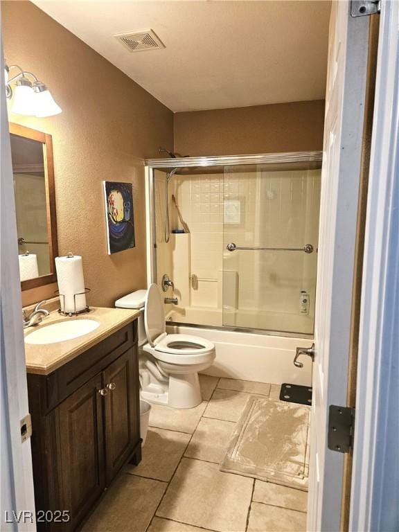 bathroom with toilet, vanity, visible vents, and tile patterned floors