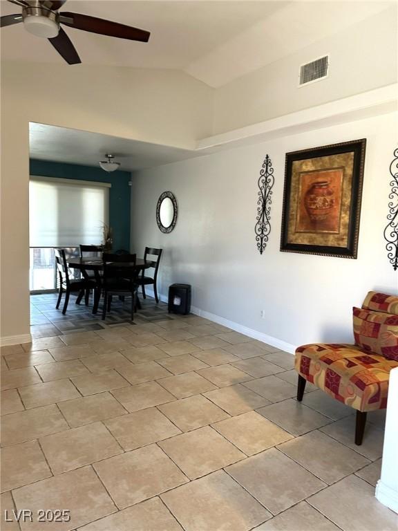 dining area with light tile patterned floors, lofted ceiling, visible vents, ceiling fan, and baseboards