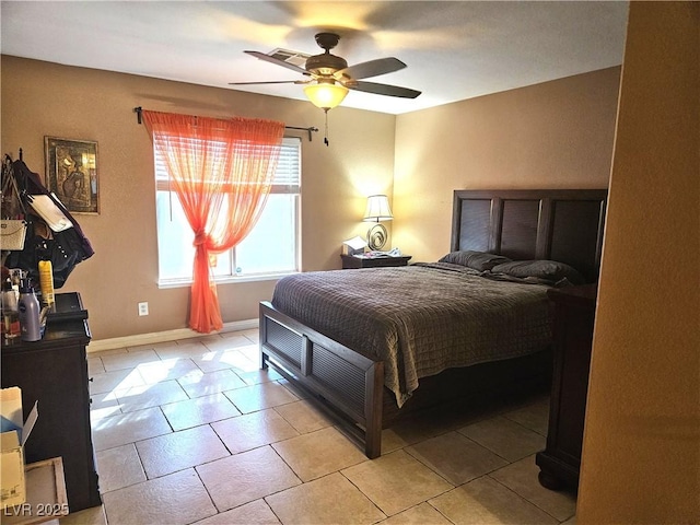 bedroom with ceiling fan, light tile patterned flooring, and baseboards