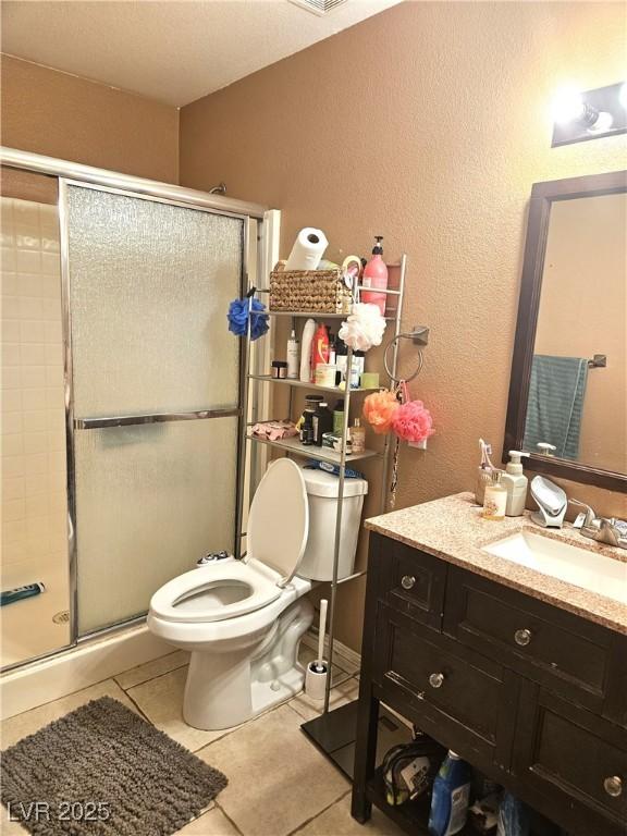 full bath with a stall shower, visible vents, toilet, tile patterned flooring, and vanity