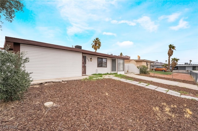 ranch-style home featuring fence