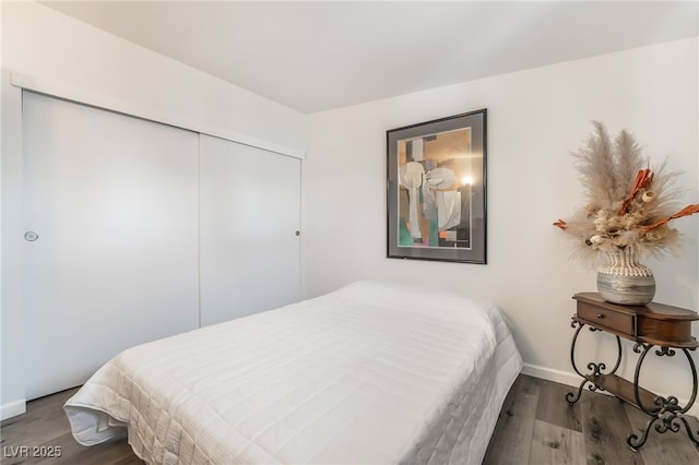 bedroom with a closet, baseboards, and wood finished floors