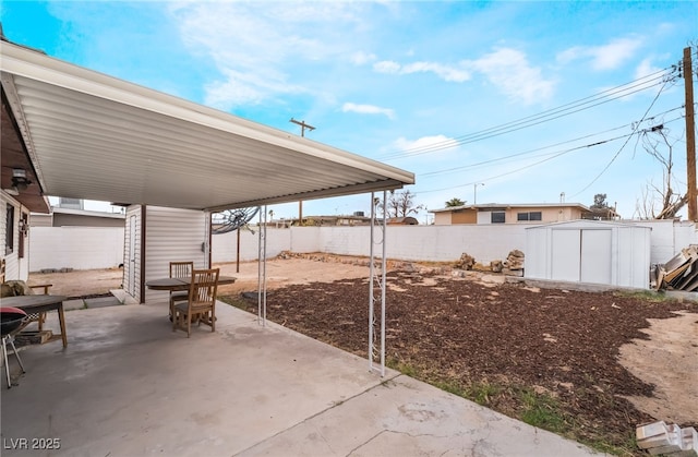 view of patio featuring an outbuilding, a fenced backyard, and a shed