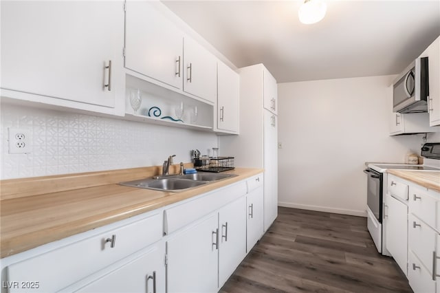 kitchen featuring dark wood-style floors, white electric range oven, stainless steel microwave, white cabinets, and a sink