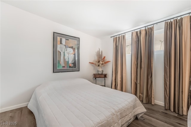 bedroom featuring wood finished floors and baseboards