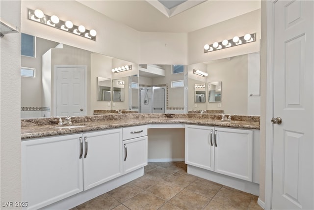 bathroom with tile patterned flooring, a shower stall, and vanity