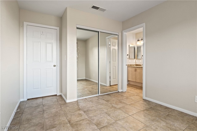 845 Holly Lake Way, Henderson, NV 89002 - unfurnished bedroom with a closet, light tile patterned flooring, visible vents, baseboards, and ensuite bath