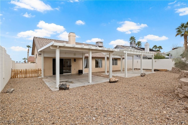 rear view of house with stucco siding, a fenced backyard, a patio, and a pergola