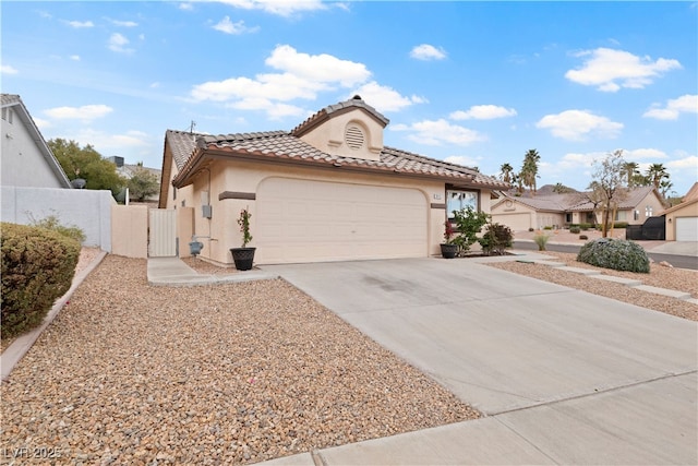 view of front facade featuring an attached garage, concrete driveway, a tiled roof, a gate, and stucco siding