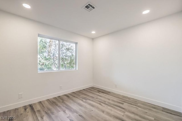 empty room with light wood finished floors, baseboards, visible vents, and recessed lighting