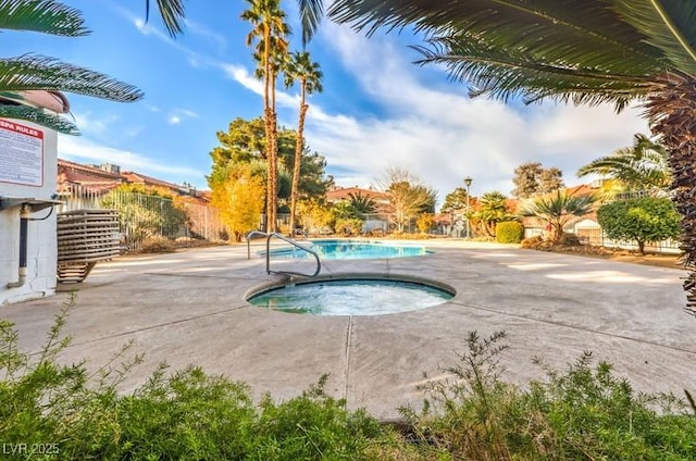 view of swimming pool with an in ground hot tub, a patio, fence, and a fenced in pool