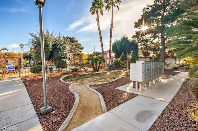 view of community featuring fence and mail area