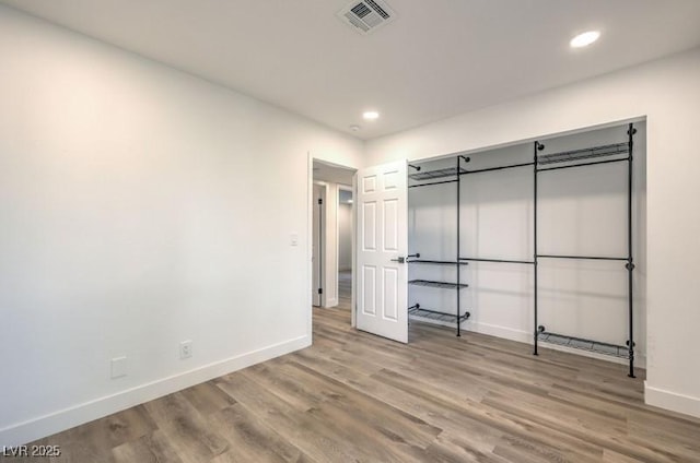 unfurnished bedroom featuring baseboards, visible vents, wood finished floors, and recessed lighting