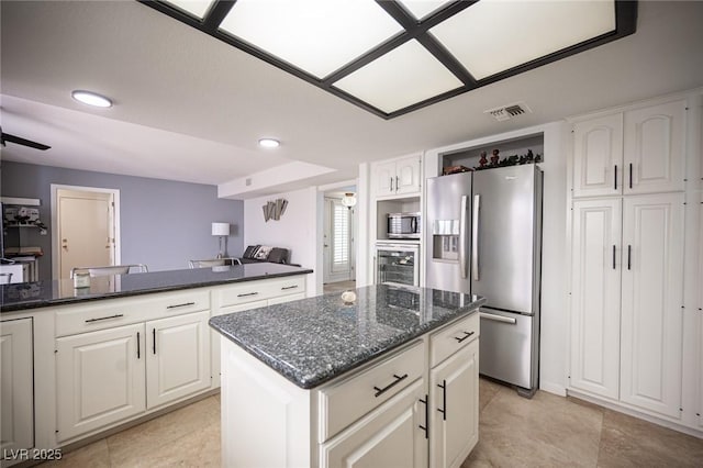 kitchen featuring a center island, visible vents, appliances with stainless steel finishes, white cabinets, and dark stone counters