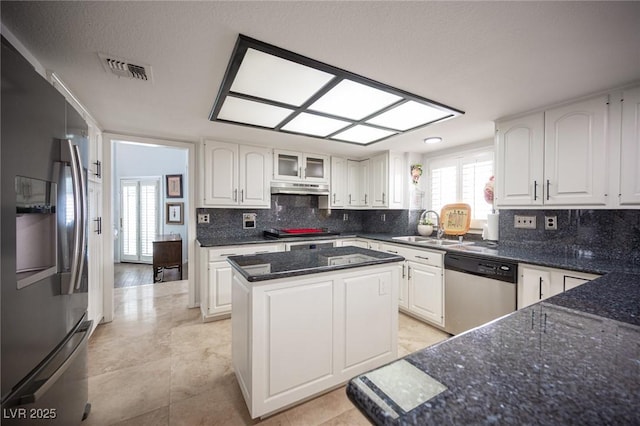 kitchen with under cabinet range hood, a sink, white cabinetry, visible vents, and appliances with stainless steel finishes