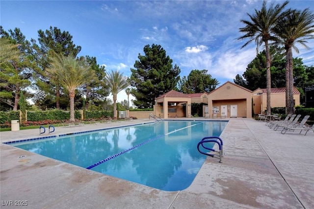 community pool featuring a patio and fence