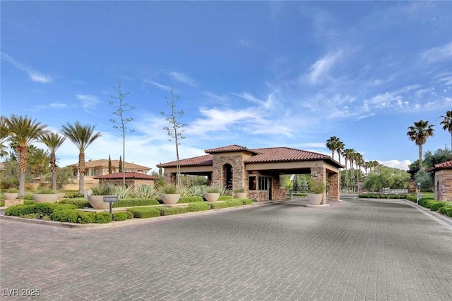 mediterranean / spanish home featuring stone siding and a tile roof