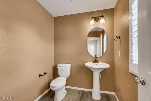 bathroom featuring wood finished floors, toilet, and baseboards