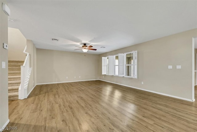 unfurnished living room with stairs, ceiling fan, light wood-type flooring, and visible vents