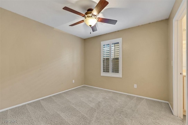 carpeted spare room featuring ceiling fan and baseboards