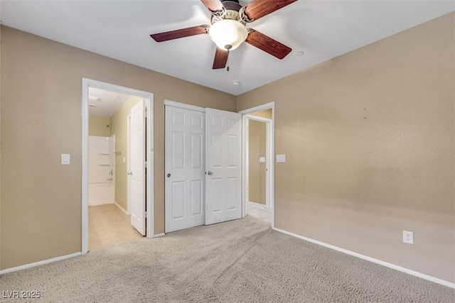 unfurnished bedroom with ceiling fan, a closet, carpet flooring, and baseboards