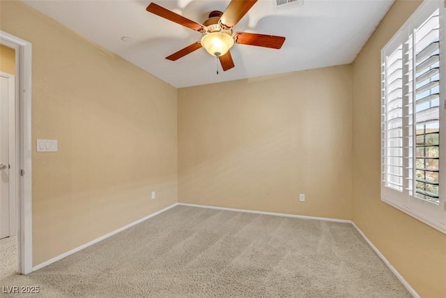 carpeted empty room featuring visible vents, baseboards, and a ceiling fan