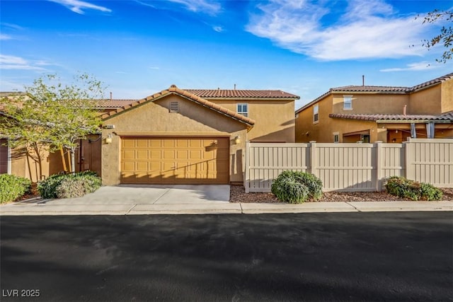 mediterranean / spanish-style house with a garage, fence, concrete driveway, and stucco siding