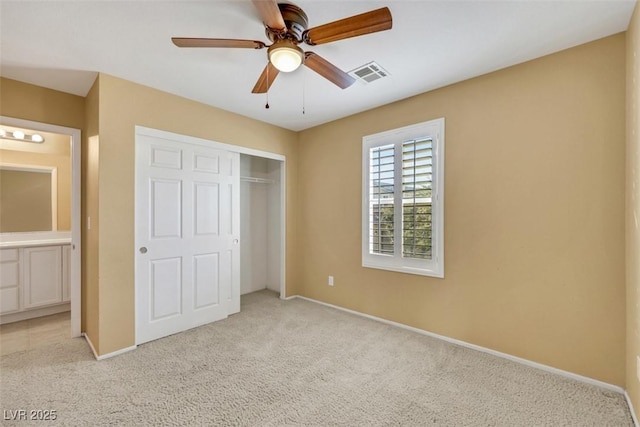 unfurnished bedroom with baseboards, visible vents, a ceiling fan, carpet flooring, and a closet