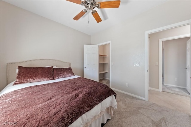 bedroom with carpet floors, a spacious closet, vaulted ceiling, ceiling fan, and baseboards